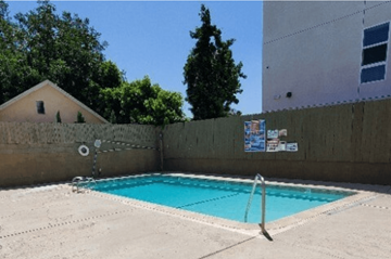 Van Nuys apartment for rent - A small pool with a diving board in the middle of a concrete floor.