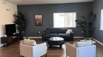 Folsom apartment for rent - A living room with a black couch, a white chair, and a coffee table.