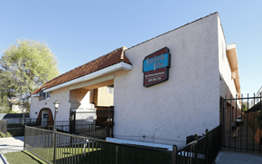 Van Nuys apartment for rent - A white building with a red roof and a sign that says "Santana".