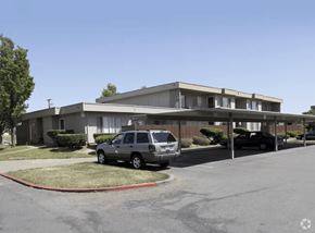 Fairfield apartment for rent - A car is parked in a parking lot in front of a building.