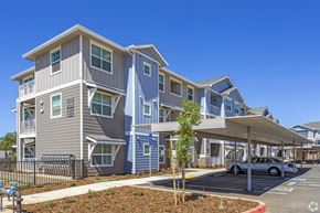 Elk Grove apartment for rent - A modern apartment complex with a parking area in front.
