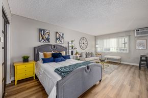North Hollywood apartment for rent - A bedroom with a bed, nightstand, and a yellow dresser at The Marquee Apartments, North Hollywood 91605