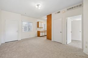 Verdugo City apartment for rent - A spacious room with a carpeted floor and white walls.