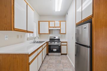 Verdugo City apartment for rent - A kitchen with a stainless steel refrigerator and wooden cabinets.