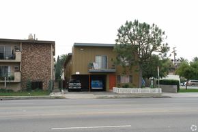 Van Nuys apartment for rent - A street view of a residential area with two houses and a car parked in front of one house.