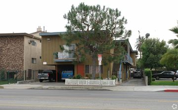 Van Nuys apartment for rent - A building with a brown and tan exterior and a white picket fence in front.