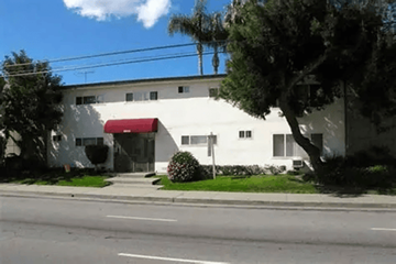 Canoga Park apartment for rent - A white building with a red awning sits on the corner of a street.