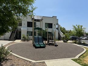 Arleta apartment for rent - a playground in front of a white building with a slide