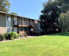 San Jose apartment for rent - A sunny day at a well-kept apartment complex with green lawns and trees.