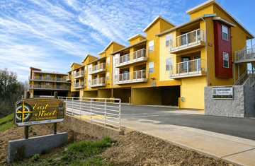 Redding apartment for rent - A yellow building with a sign that says "Eastwood" in front of it.