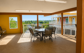 Redding apartment for rent - A dining table with chairs is in a room with yellow walls and a view of the outdoors.