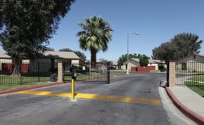Coachella apartment for rent - a city street with a palm tree and a black fence
