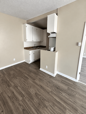 Reseda apartment for rent - A kitchen with white cabinets and a wooden floor.