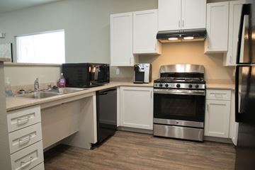 Live Oak apartment for rent - A kitchen with white cabinets and a black fridge.