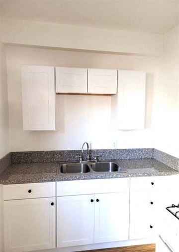 Long Beach apartment for rent - a kitchen with white cabinets and a sink