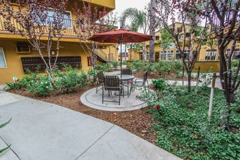 A patio with an umbrella and tables in a courtyard