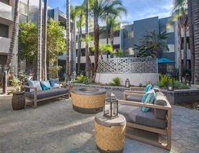 Los Angeles apartment for rent - A patio area with wicker furniture and a stone wall.