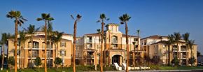 Buena Park apartment for rent - A large building with palm trees in front of it.