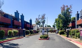 Selma apartment for rent - A street view of a residential area with houses on both sides and a sign in the middle of the road.