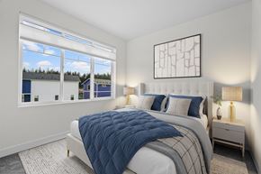 Port Orchard apartment for rent - A bedroom with a large bed and a view of the outside through the window.