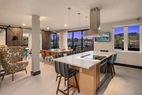 Woodinville apartment for rent - a large kitchen with a large island and a dining area with chairs and a bar
