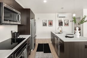 Seattle apartment for rent - a modern kitchen with stainless steel appliances and white counter tops