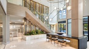 Redmond apartment for rent - A modern interior space with a staircase, tables, and chairs.