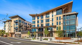 Woodinville apartment for rent - A modern building with a large glass window and a wooden roof.
