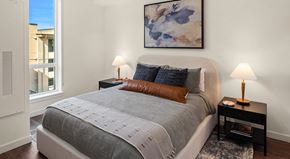 Woodinville apartment for rent - A bedroom with a large bed and a painting on the wall.