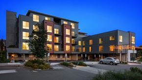 Kenmore apartment for rent - A modern apartment building with a parking lot in front.
