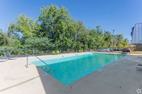 Nashville townhouse for rent - A swimming pool surrounded by trees and a fence.