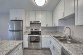 Nashville townhouse for rent - A kitchen with white cabinets and granite countertops.