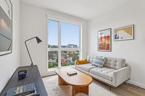 Los Angeles apartment for rent - A living room with a couch, a coffee table, and a large window overlooking a cityscape.