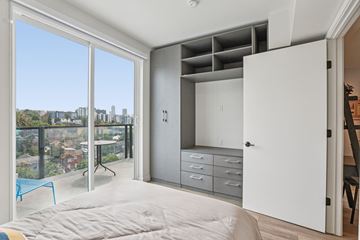 Los Angeles apartment for rent - A bedroom with a large bed and a balcony overlooking a cityscape.
