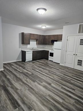 Wichita apartment for rent - A kitchen with white appliances and wooden cabinets.