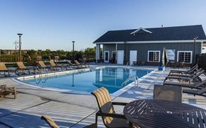 Wichita apartment for rent - a swimming pool with chairs and tables around it