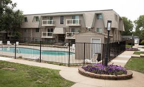 Wichita apartment for rent - an apartment building with a pool and a fence