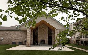 Wichita apartment for rent - a brick building with a patio and a tree