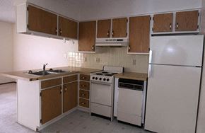 Wichita apartment for rent - a kitchen with white appliances and wooden cabinets