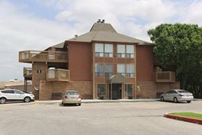 Wichita apartment for rent - a building with cars parked in a parking lot