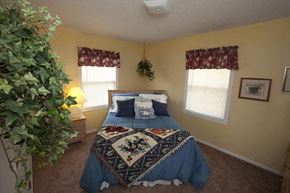 Wichita apartment for rent - a bedroom with a bed and a potted plant
