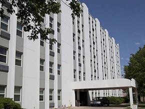 Wichita apartment for rent - a large white building with a car parked in front of it