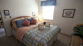 Wichita apartment for rent - a bedroom with a bed and a table on top of it
