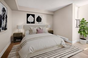 Ottawa apartment for rent - A bedroom with a large bed and a plant.