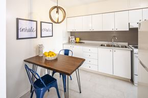 Ottawa apartment for rent - A kitchen with a table and chairs and a fridge.