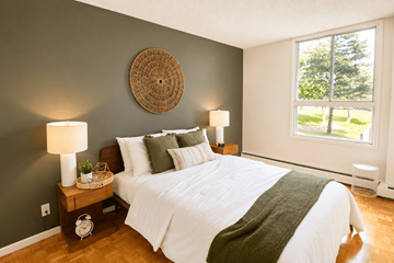 Ottawa apartment for rent - A bedroom with a white bed and a green blanket.