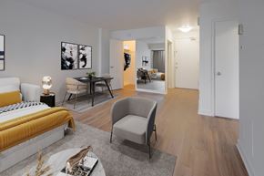 Ottawa apartment for rent - A modern bedroom with a yellow bed and a grey armchair.