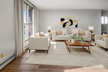 Ottawa apartment for rent - A living room with a white couch, a coffee table, and a painting on the wall.