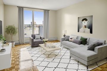 Ottawa apartment for rent - A living room with a grey couch, a coffee table, a chair, a potted plant, and a painting on the wall.