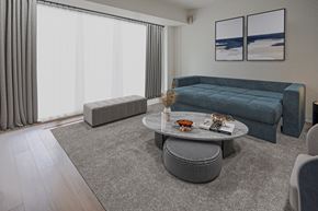 Ottawa apartment for rent - A living room with a grey sofa, a grey coffee table, and a grey ottoman.